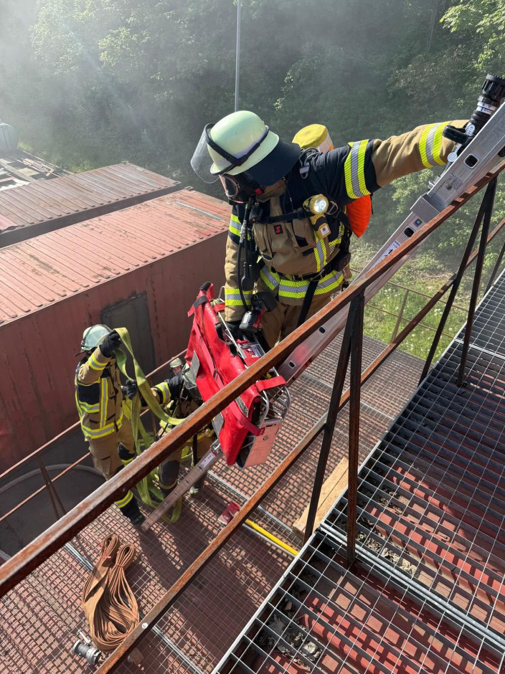 Feuerwehrleute auf einer Leiter an der Übungsanlage