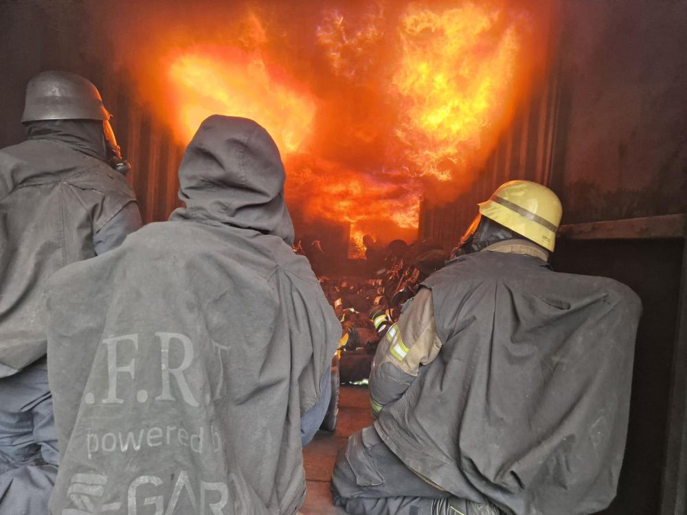 Feuerwehrleute im brennenden Container