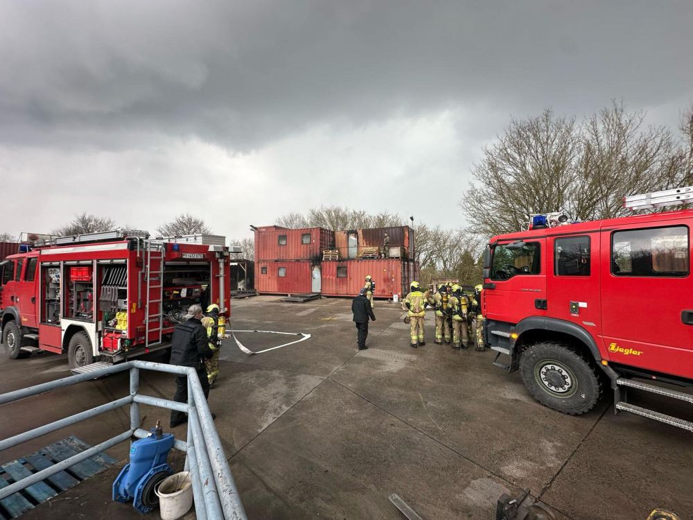 Mehrere Gruppen und Feuerwehrautos auf dem Übungsgelände