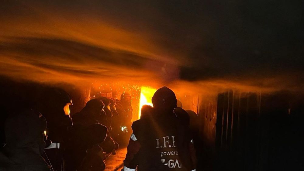 Feuerwehrleute in brennendem Container